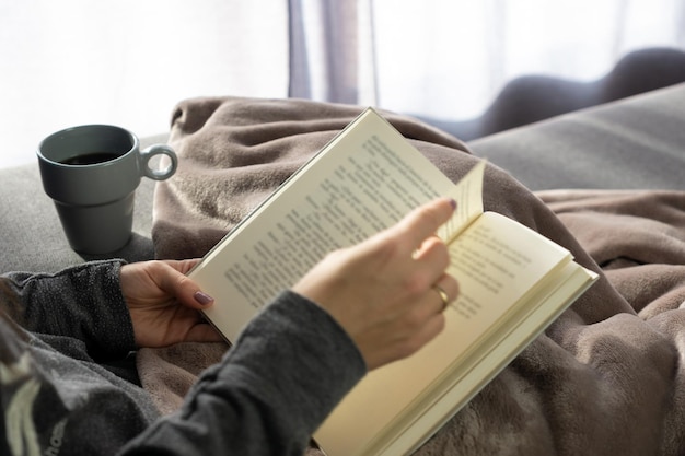 Woman's hands holding a book while seated