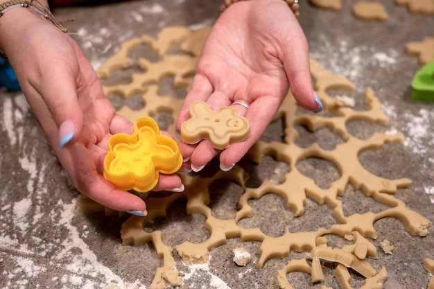 Woman's hands holding cookie cutter and cookie Baking at home preparing home meal content
