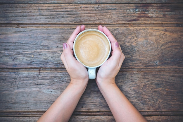 女性の手がコーヒーを飲みながら