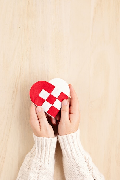 Woman's hands holding red and white heart