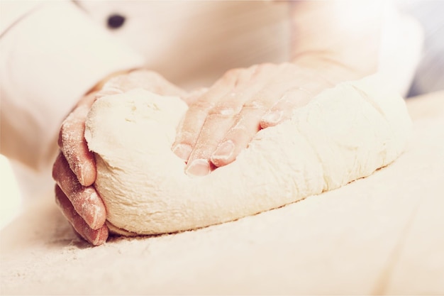 Woman's hands knead the dough, close-up view