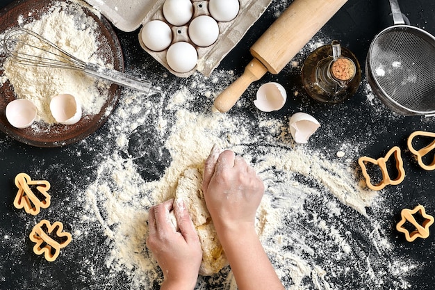 Фото Женские руки месят тесто на столе с мучными яйцами и ингредиентами вид сверху