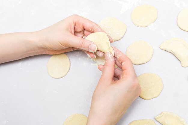 Woman's hands make ravioli