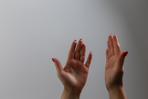 Woman's hands praying against a white background