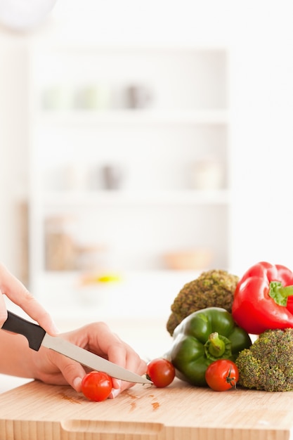 Woman's hands slicing tomatoes