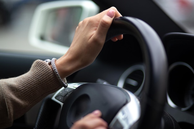 Woman's hands on the steering wheel in the car