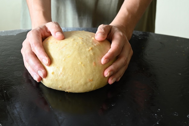 Woman's hands surrounding a ball of dough