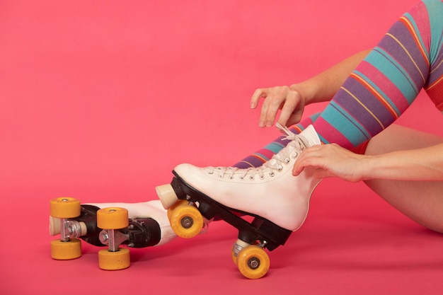 Woman's hands tying the laces of her 4-wheeled skate boots