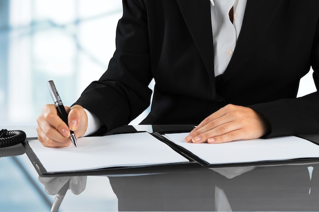 Woman's hands with pen signing document, close up