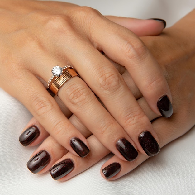 A woman's hands with a ring on the left hand and a ring on the right hand.