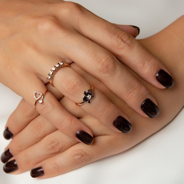 A woman's hands with a ring on the left hand and a ring on the right hand.