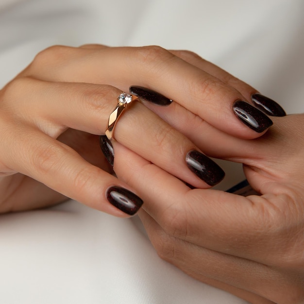 A woman's hands with a ring on the top of it and a diamond on the top.