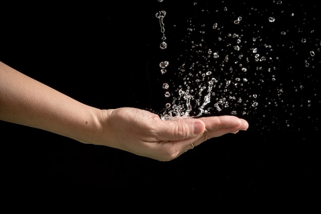 Foto le mani della donna con spruzzi d'acqua