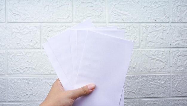 Woman's hold envelope over white wall background