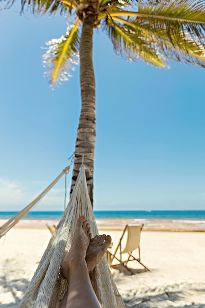 Woman's legs in the hammock against the ocean view