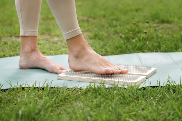 Woman on a sadhu board meditates close-up