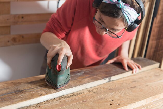 Woman sanding a restored wood