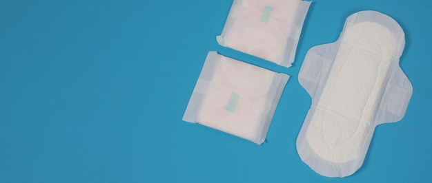 woman sanitary napkins on blue background top view absorbent pads worn by women to absorb menstrual blood comfortable white sanitary napkins arranged on light blue paper represent hygiene concept