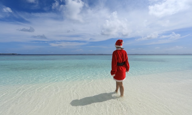 woman santa claus on the shore of a tropical island