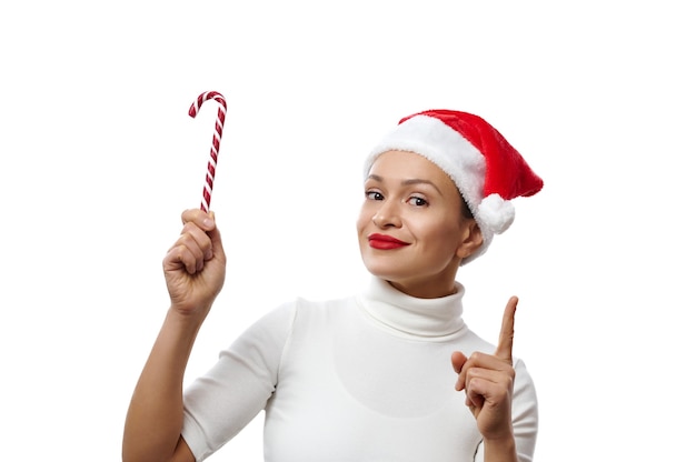 woman in a santa hat holds candy cane