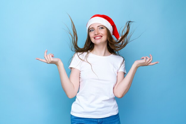 Woman in santa hat is very happy and happy she shows gesture of victory she achieved the result the ...