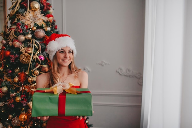 женщина в новогодней шапке с рождественскими подарками