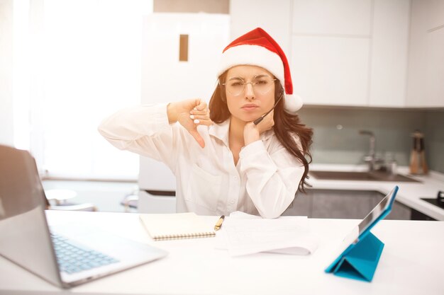 Woman in Santa hat working on a laptop