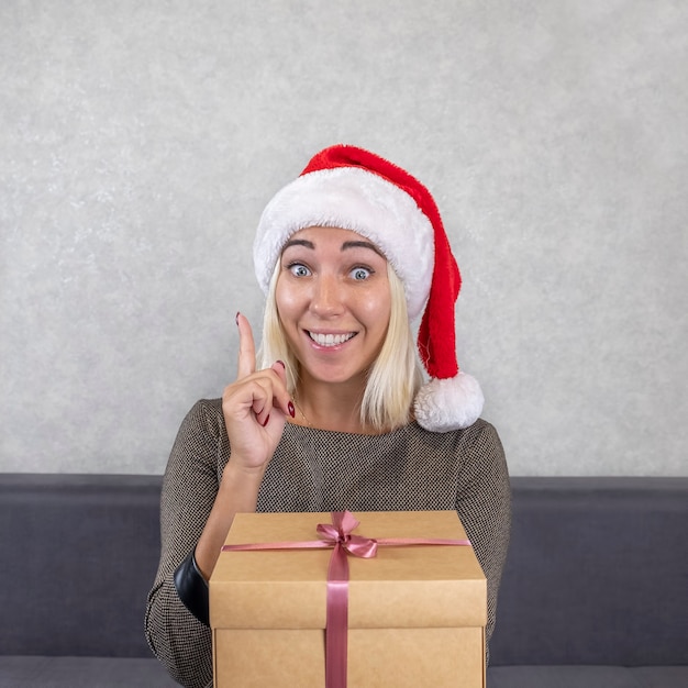 Woman in Santa's hat pointing an idea.