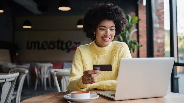 Woman sat with a laptop and paid with a credit card in a cafe