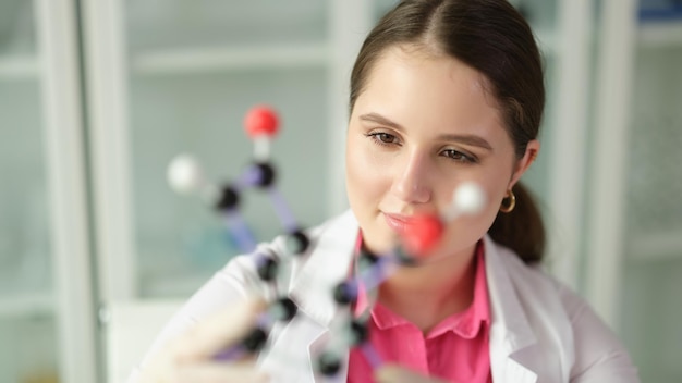 Woman scientist chemist in front of molecule in chemical laboratory