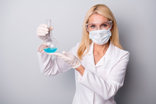 woman scientist holds chemical liquid flask