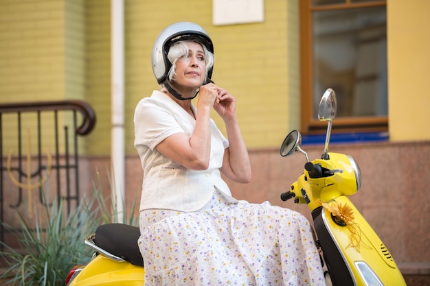 Woman on scooter wearing helmet.