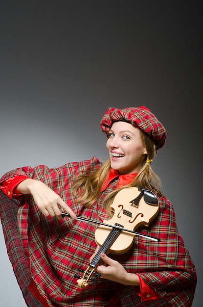 Photo woman in scottish clothing in musical concept