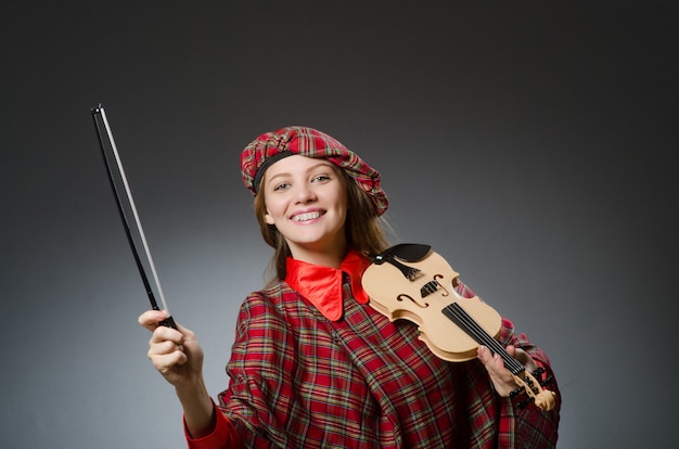 Photo woman in scottish clothing in musical concept