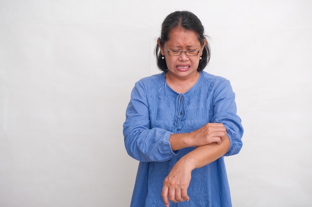 A woman scratches her itchy arm