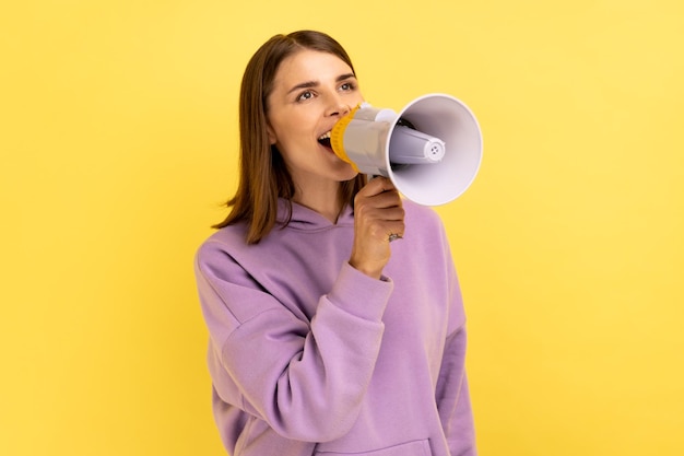 Woman screaming loudly in megaphone announcing important advertisement protesting