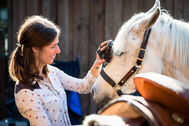 Photo woman scrubbing white horse