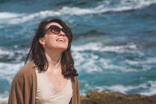 Женщина на морском пляже наслаждается силой природы в ветреную погоду