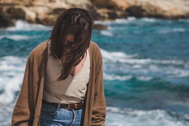 Woman at sea beach enjoying power of nature windy weather