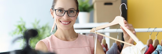 Cucitura della donna che mostra il vestito bianco sulla gruccia davanti alla telecamera