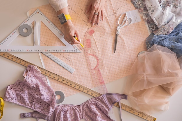 a woman seamstress designs and draws a pattern for underwear on graph paper