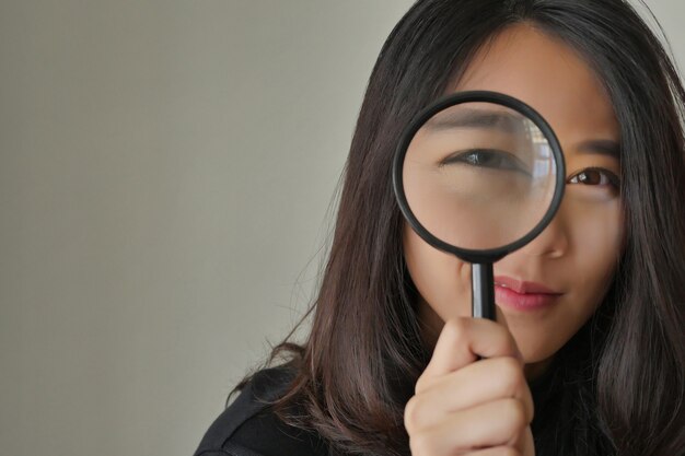 Woman searching, viewing, finding with magnifying glass, girl searching concept