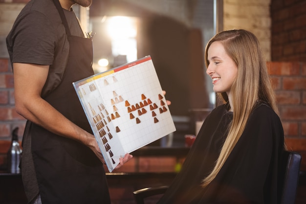 Woman selecting a hair color with stylist