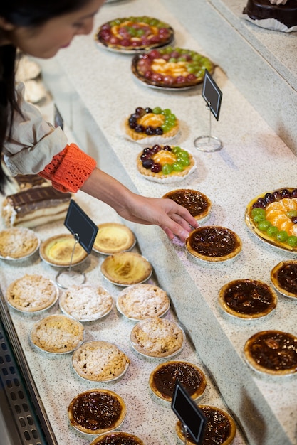 Woman selecting tart from display