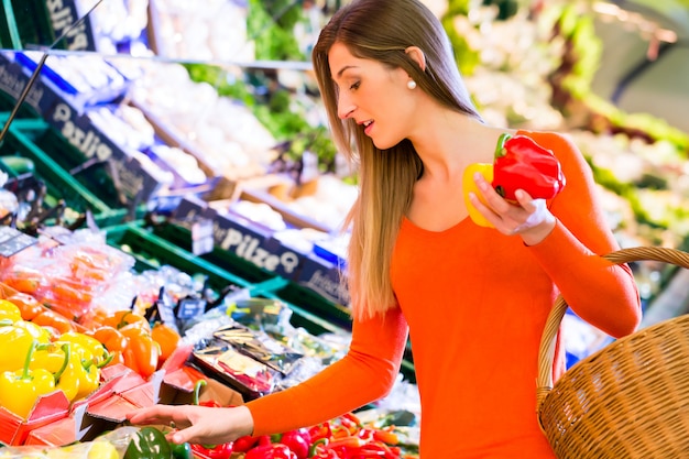 Woman selecting vegetables in grocery store