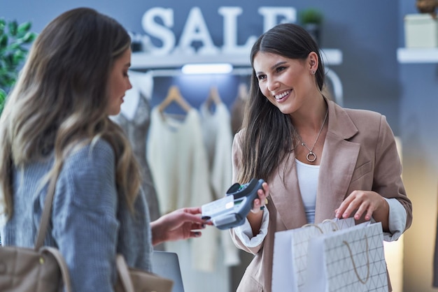 Woman seller and buyer in clothes store. High quality photo