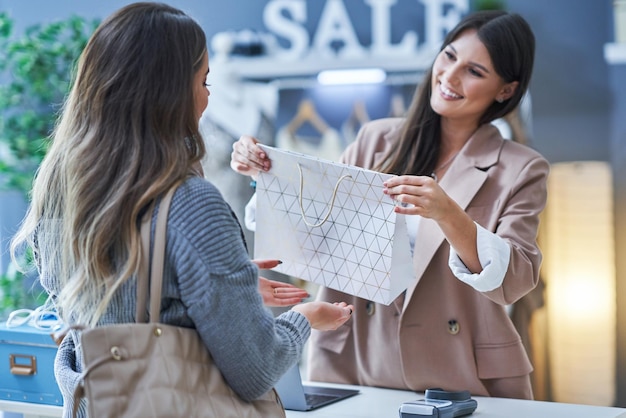 Woman seller and buyer in clothes store. High quality photo