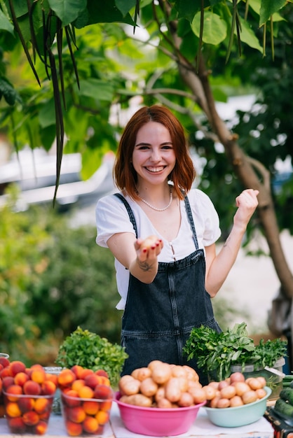 Женщина-продавец за прилавком с овощами Концепция малого бизнеса