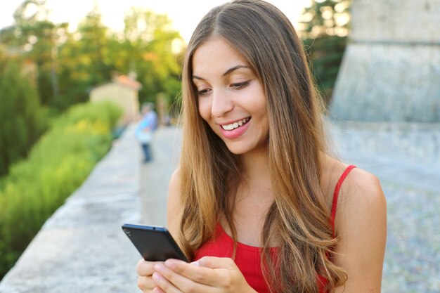 La donna invia messaggi con l'applicazione sul telefono cellulare all'aperto