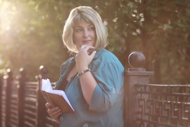 woman senior in park with book